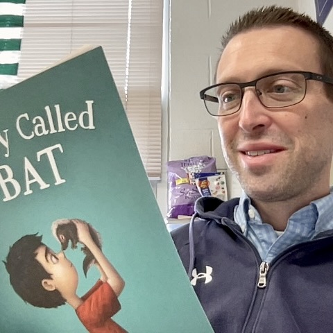 Photo of Mr. Eshelman holding a book